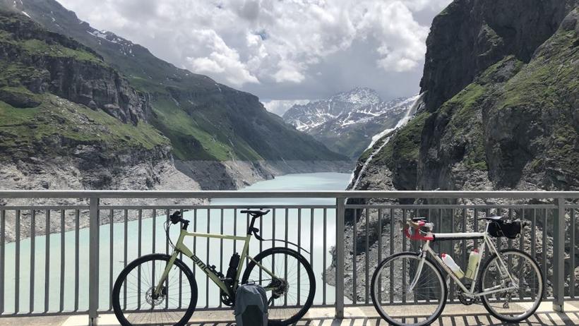Two bicycles on the Mauvoisin dam above a turquoise lake